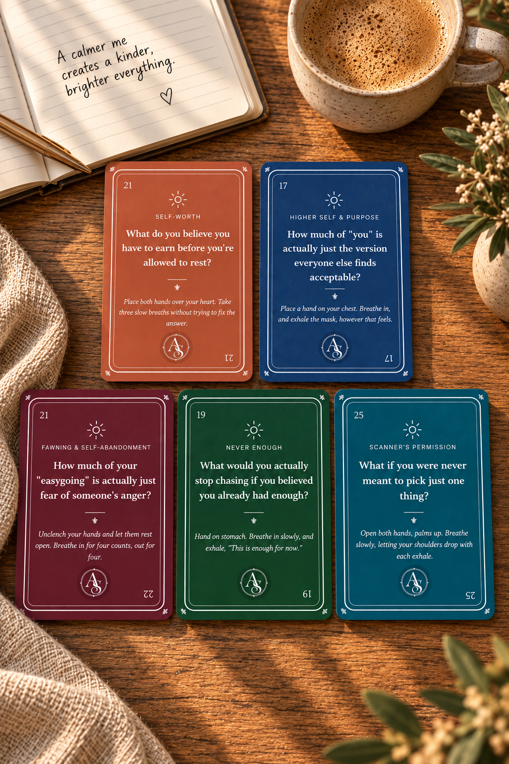 Five Awakening Shift practice cards laid out on a rustic wooden table beside an open journal, a gold pen, a coffee mug, and greenery.